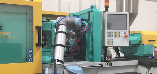 תמונה 2: קובוט UR10 מבית Universal Robots מבצע משימות לצד מכונת הזרקה של Arburg